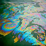 Colorful patterns in an oil spill on polluted water.