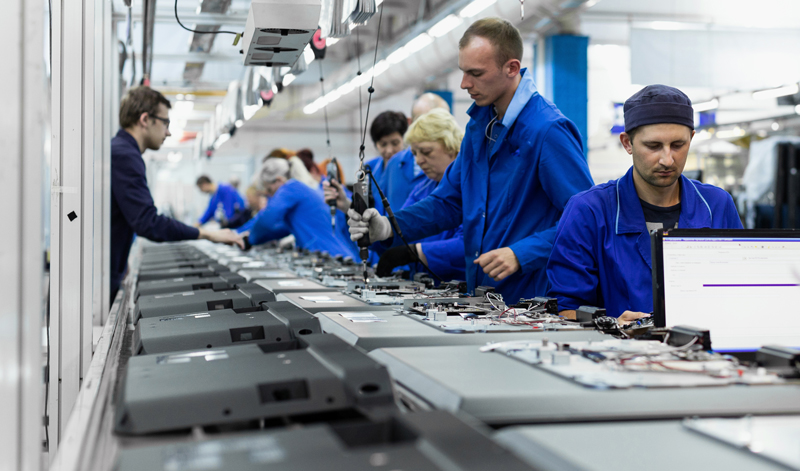 Workers at the conveyor belt in a laptop computer factory.