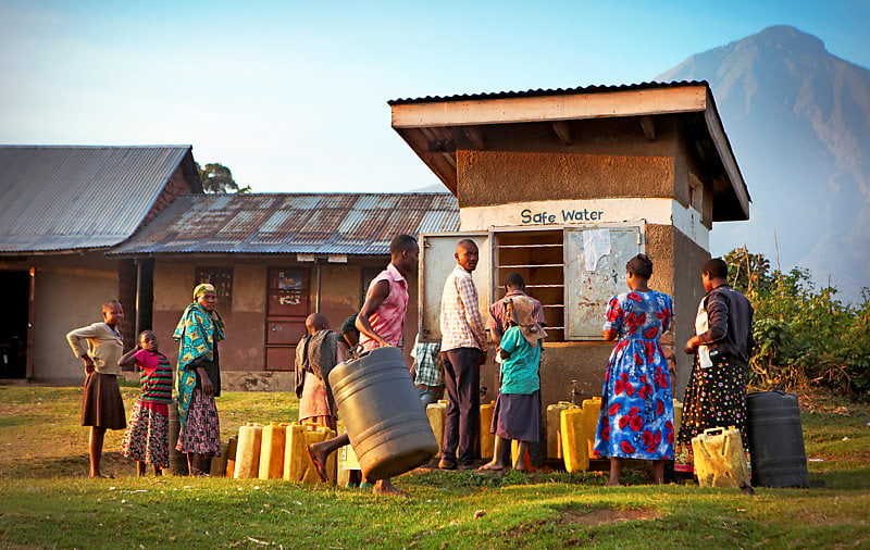 Local villagers waiting with plastic canisters to get safe water from a public water well.