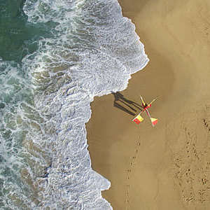 Lifeguard walking on beach with flags