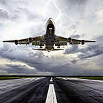 Low-angle shot of a passenger aircraft landing in extreme weather.